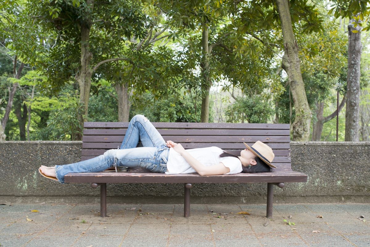 Woman to take a nap on a park bench